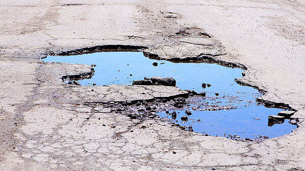 A pothole filled with water.
